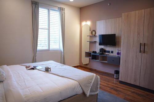 sypialnia z dużym łóżkiem i telewizorem w obiekcie THE CONTINENTAL INN & SUITES w mieście Mysuru