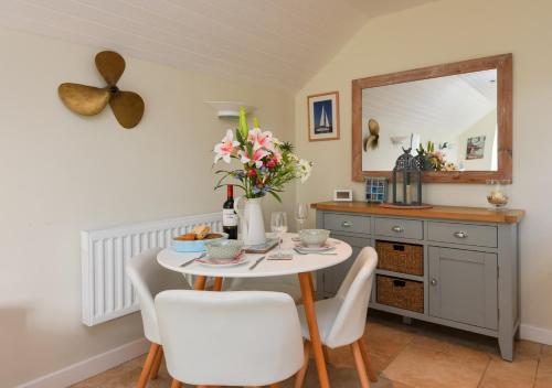 a dining room with a table and a mirror at Y Ddol Bach in Abersoch