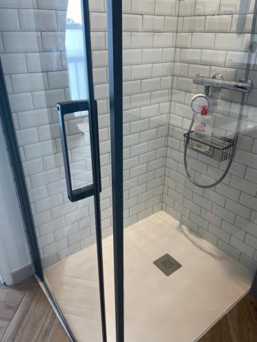 y baño con ducha y azulejos blancos de metro. en Gîtes d'Izel n°2, en Ploemel