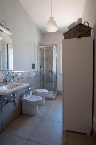 a bathroom with two toilets and a shower and a sink at Le case del Duca in Ioppolo Giancaxio