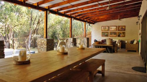 a large wooden table with a bench in a room at Dream of Africa Bush Lodge in Marloth Park