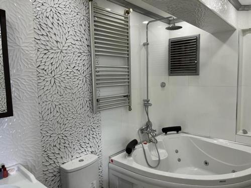 baño blanco con bañera y aseo en Karamürsel Mohti Otel Fitness Organizasyon en Karamürsel
