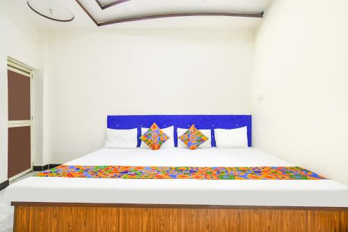 a bedroom with a large bed with colorful sheets at FabExpress High Star in Ujjain