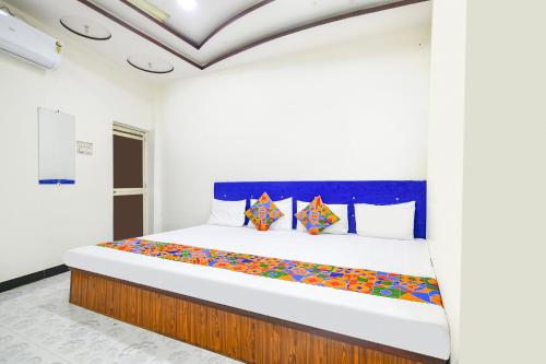 a bedroom with a large bed with colorful pillows at FabExpress High Star in Ujjain