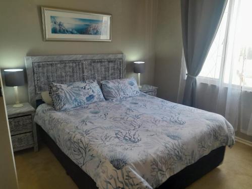 a bedroom with a bed with blue and white sheets at La Corsica 9 in Margate