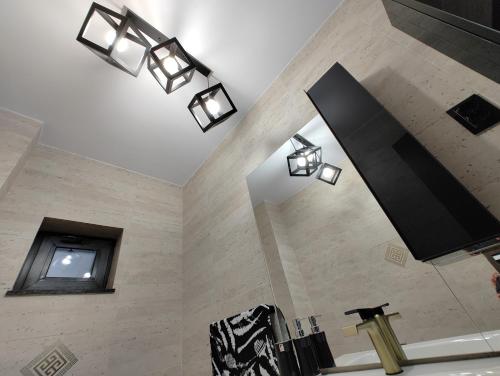 a bathroom with several lights on a wall at Black&White House in Ocna-Mureşului