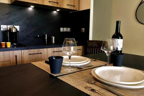 - une table avec 2 verres et une bouteille de vin dans l'établissement L'Amazone-Appart au calme avec balcon et parking, à Nantes
