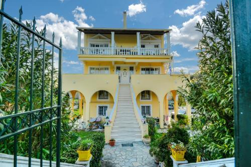 a yellow house with a staircase leading up to it at Sunshine House in Episkopianá