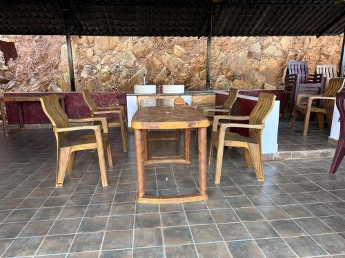 a wooden table and chairs on a patio at Ikshana Cottages in Kalasa