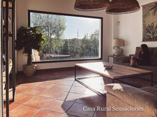 sala de estar con mesa y ventana grande en Sensaciones en Castaño de Robledo
