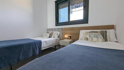 a bedroom with two beds and a mirror on the wall at SUNSET WAVES luxury apartment in Benidorm