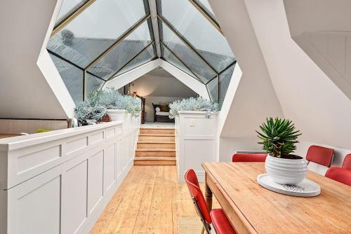 an attic dining room with a wooden table and red chairs at Blackwood Tree Cottage Heritage Listed Evandale in Evandale