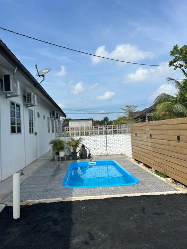 a swimming pool in a yard next to a house at Cantik-La Homestay Kolam 3 Bilik Kuala Terengganu in Bukit Payong