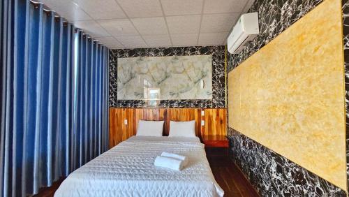 a bedroom with two beds and blue curtains at Sông Hotel PQ - by BAY LUXURY in Phu Quoc