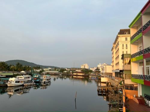 a river with boats docked next to some buildings at Sông Hotel PQ - by BAY LUXURY in Phu Quoc