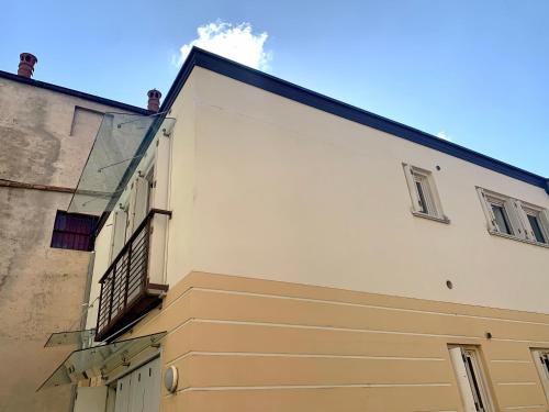 a white building with a staircase on the side of it at In centro a due passi dal lago in Iseo
