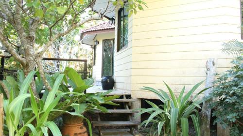 uma casa com uma escada que leva até uma porta em Navari Homestay em Rayong