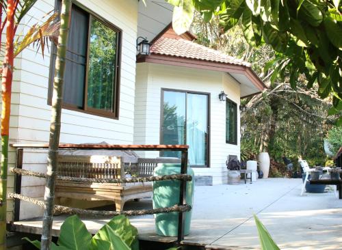 a house with a bench in front of it at Navari Homestay in Rayong