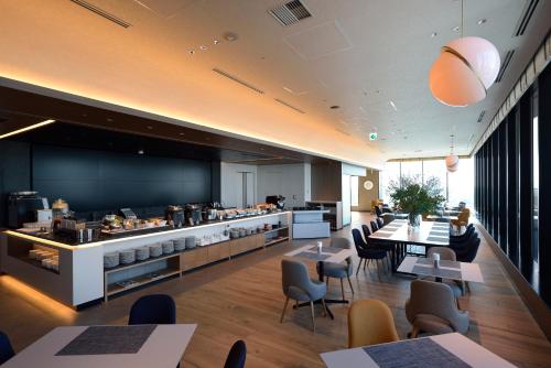a restaurant with tables and chairs and a kitchen at Hyatt House Tokyo Shibuya in Tokyo