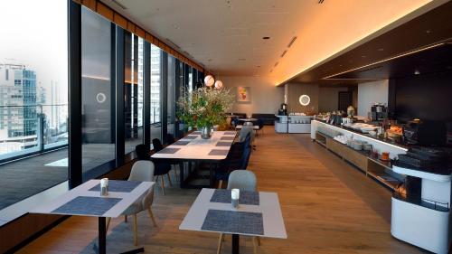 a restaurant with tables and chairs and large windows at Hyatt House Tokyo Shibuya in Tokyo