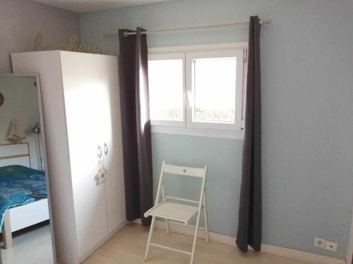 a bedroom with a window and a chair and a mirror at Au fil de l'eau in Conchy-sur-Canche