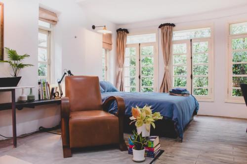 Schlafzimmer mit einem Bett, einem Stuhl und Fenstern in der Unterkunft Bunker - The Suite in Ho-Chi-Minh-Stadt