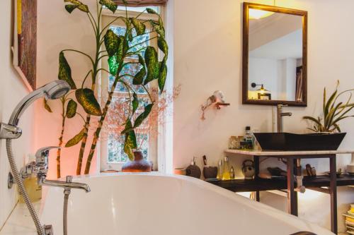 ein Bad mit einer Badewanne und einem Spiegel in der Unterkunft Bunker - The Suite in Ho-Chi-Minh-Stadt