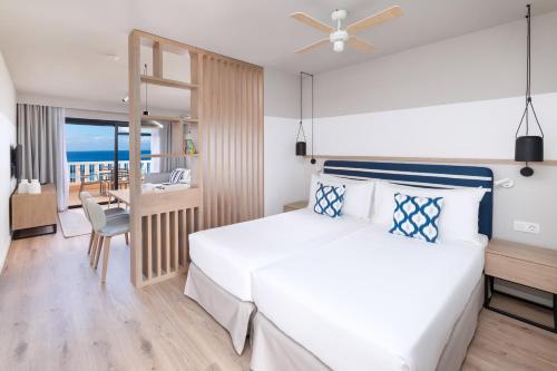 a bedroom with a bed and a view of the ocean at Sol Sun Beach Apartamentos in Adeje