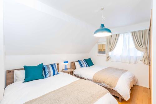 a bedroom with two beds and a window at Modern House Tokyo east in Tokyo