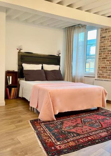 - une chambre avec un lit rose et un tapis dans l'établissement 123 Honfleur, à Honfleur