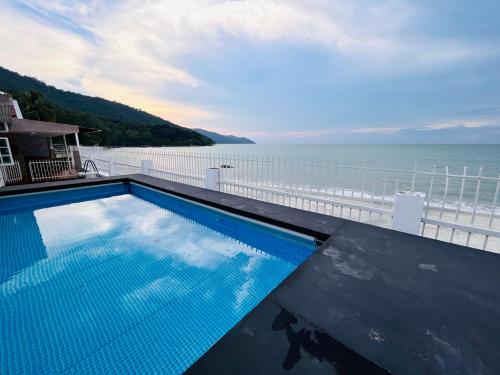 a swimming pool with a view of the ocean at Seaview Mini Chalet - Direct Beach Access in Tanjung Bungah
