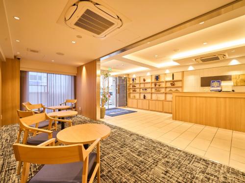 a lobby of a hotel with tables and chairs at Kyoto Daiichi Hotel in Kyoto