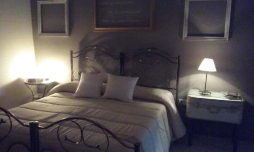 a bedroom with a large bed with two tables and two lamps at Le Dimore degli Artisti in Venosa