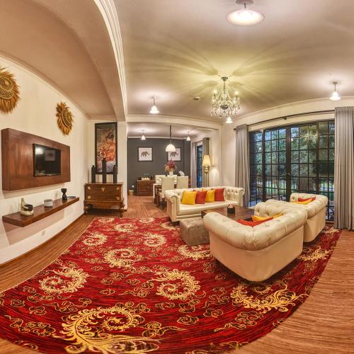 a large living room with couches and a red rug at Covanro Sigiriya - Where Heritage Meets Luxury in Sigiriya