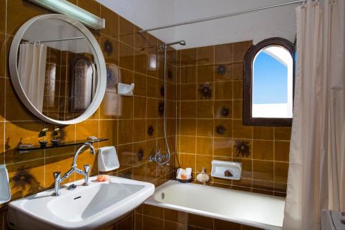 a bathroom with a sink and a mirror and a tub at Hotel Malia Holidays in Malia