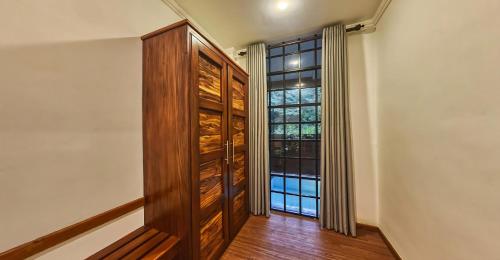 a hallway with a large wooden cabinet and a window at Covanro Sigiriya - Where Heritage Meets Luxury in Sigiriya