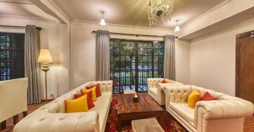 a living room with two white couches and a chandelier at Covanro Sigiriya - Where Heritage Meets Luxury in Sigiriya