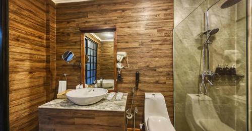 a bathroom with a sink and a tub and a toilet at Covanro Sigiriya - Where Heritage Meets Luxury in Sigiriya