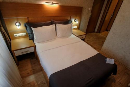 a bedroom with a large bed and two night stands at Rhisos Otel in Rize