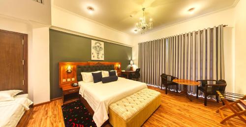a bedroom with a bed and a table and chairs at Covanro Sigiriya - Where Heritage Meets Luxury in Sigiriya