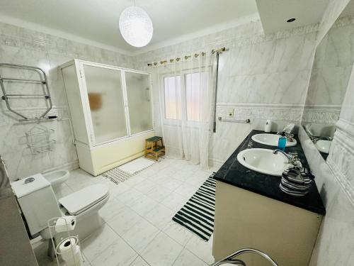 ein weißes Bad mit einem Waschbecken und einem WC in der Unterkunft DMCharme in Ponta Delgada