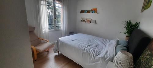 une chambre avec un lit, une chaise et une fenêtre dans l'établissement Villa avec piscine - Mougins - domaine privé, à Mougins