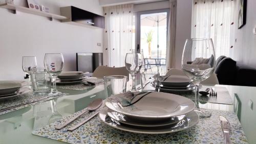 een tafel met borden en wijnglazen erop bij MIRADOR Poniente beach apartments in Benidorm