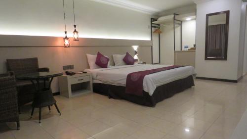 a hotel room with a bed and a table and a desk at Heritage Hotel in Tawau