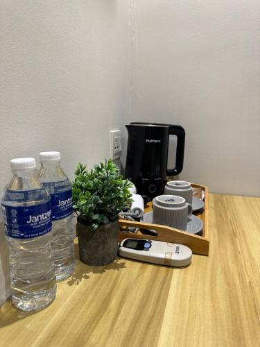 a table with two bottles of water and a coffee maker at Swing & Pillows - KL Pekeliling formerly known as Swiss Cottage Hotel in Kuala Lumpur