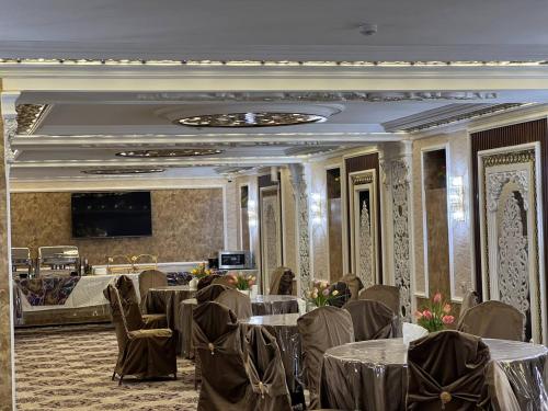 um salão de banquetes com mesas e cadeiras numa sala em The Afrosiyob Ok em Samarkand