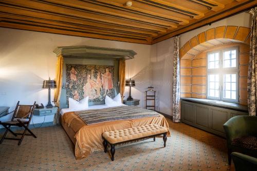 um quarto com uma cama grande e uma janela grande em Burg Rabenstein em Kirchahorn