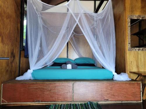 a bed in a room with a mosquito net at The Station Tioman in Tioman Island