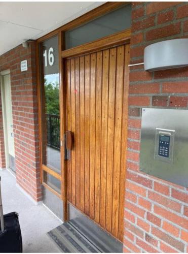 uma porta de madeira num edifício de tijolos com o número em Doktor Forselius gata 16 em Gotemburgo