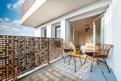- un balcon avec une table, des chaises et un lit dans l'établissement • Vue Panoramique • Gare à 10min • Parking Privé •, à Champigny-sur-Marne